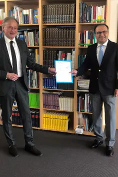 Honorarprofessor Goodarz Mahbobi erhält von Hartmut Ihne seine Ernennungsurkunde