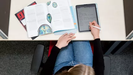 Lernen in der Bibliothek mit Tablet und Zeitschrift