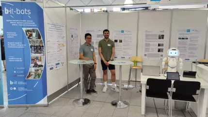 A2S Tag der Forschung 2023 stand setup with all posters, QTrobot, and a few presenters