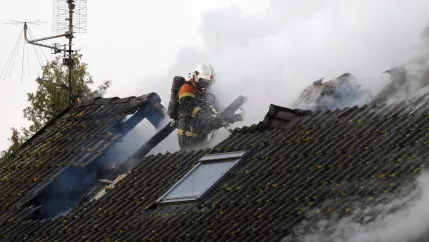 Symbolbild Feuerwehrmann in brennendem Haus