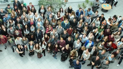 grosse_gruppe_studierende_wiwi_im_e-gebaeude_von_oben_2015_foto_y._weber_teasercut.jpg (DE)