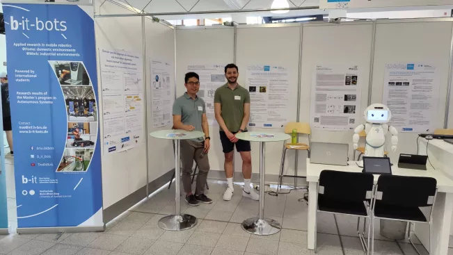 A2S Tag der Forschung 2023 stand setup with all posters, QTrobot, and a few presenters