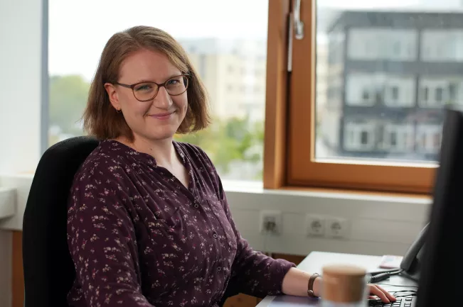Frau arbeitet an Schreibtisch Bibliothek E-Learning