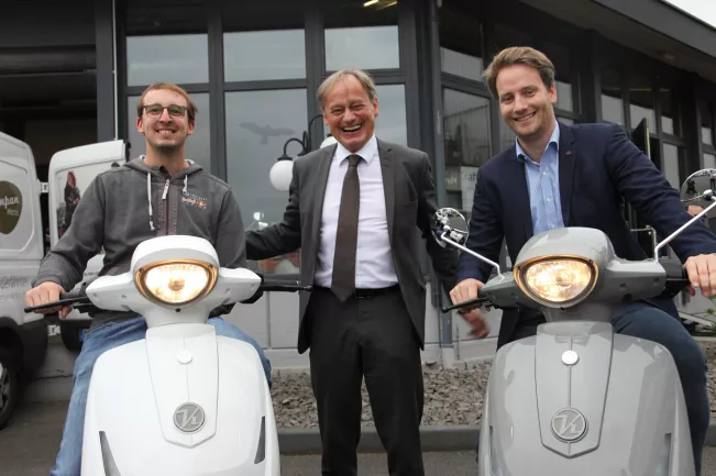 Hochschulpräsident Ihne mit  E-Scooter Kumpan Electric (DE)
