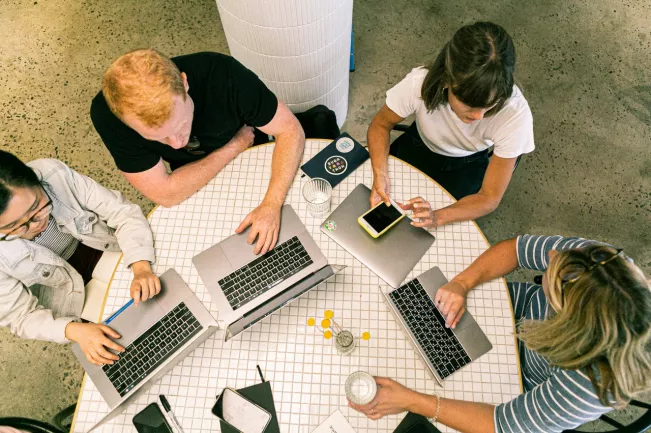 Studierende am runden Tisch mit Laptop - pexels-canva-studio-3277808.jpg (DE)