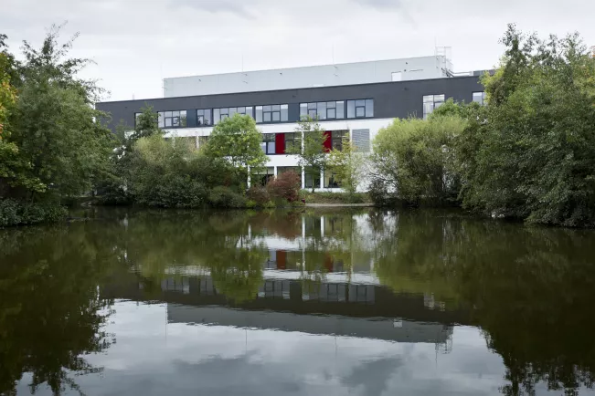 Campus Rheinbach Gebäude G, idyllischer Blick über den Teich auf das Gebäude