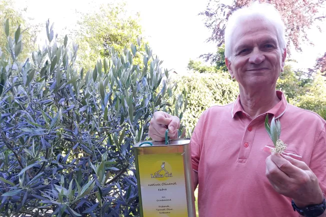 Professor Gerd Knupp mit Olivenblüte und Ölkanister